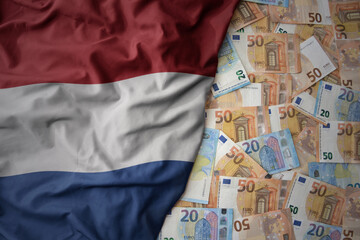 colorful waving national flag of netherlands on a euro money background. finance concept