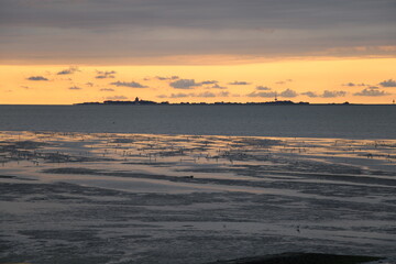 Fototapeta na wymiar Silhouette of the island of Neuwerk at sunset | As seen form Cuxhaven-Duhnen