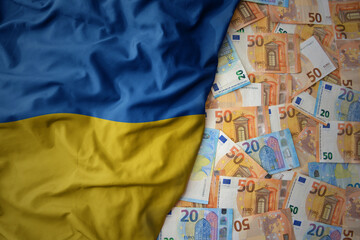 colorful waving national flag of ukraine on a euro money background. finance concept