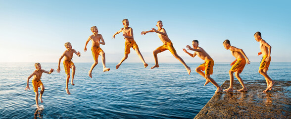 Sequence of jump. Moments of schoolboy jumping from stone pier into sea at sunrise doing tricks in combined image sequence - 673332073