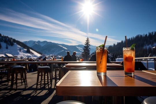 Skiurlaub auf der Skihütte. Den Winterurlaub genießen mit einem Cocktail in der Sonne in den Bergen. Restaurant Terrasse in den Alpen zum apres ski. 