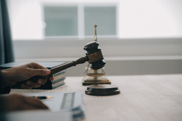 Justice and law concept.Male judge in a courtroom with the gavel, working with, computer and...