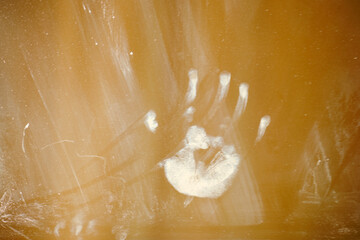 A child's palm print and dirt on the window glass from hands. Traces of baby's greasy hands on the...