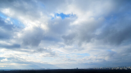 Dramatic sky with dark cumulus clouds. Menacing heavy clouds in the blue sky