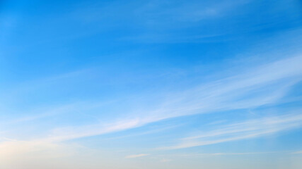 White cirrus and stratus clouds in a blue daytime sky - obrazy, fototapety, plakaty