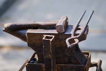 Hammer and tools for forging metal by a blacksmith. Blacksmithing in retro style outdoors