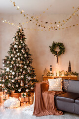 Interior of modern living room with comfortable sofa decorated with Christmas tree and gifts