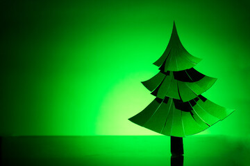 paper Christmas tree on table on green background
