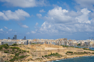 Fototapeta premium Valleta, Malta September 07 2023 skyline of historical valletta military army barracks in natural stone with modern commercial building in the background