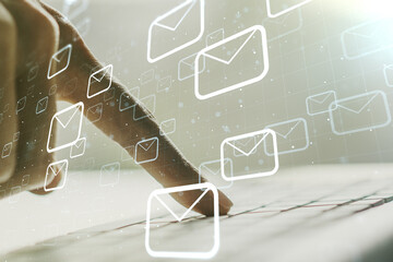 Double exposure of postal envelopes hologram with hands typing on laptop on background. Electronic...