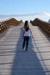 Puente via rural Delta del Guadalhorce, Málaga, niña subiendo el puente sola, vista de espaldas