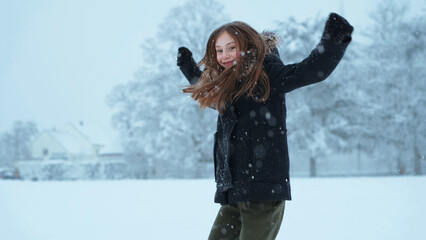 Fototapeta na wymiar Happy cute girl playing with a snow outdoors, winters holidays concept. Snowy weather.