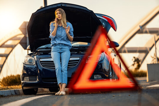 Woman driver using mobile phone during problem car