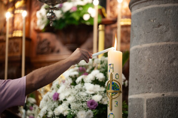 hand lighting baptism candle in church - obrazy, fototapety, plakaty