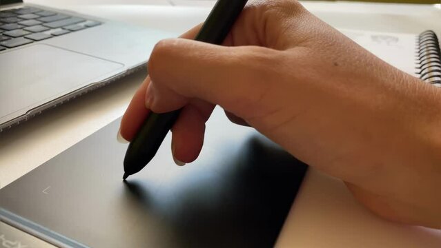 Close-up of a hand working with a pencil for a graphics tablet