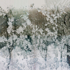 Winter background on transparent glass window with frozen texture.