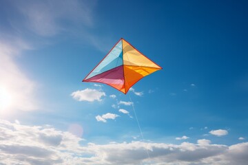 Colorful kite flying in the blue sky - obrazy, fototapety, plakaty
