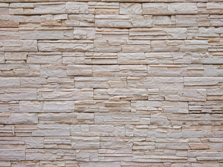 Beige stone wall texture with stacked bricks, ideal for modern architecture, home decor, and construction design elements