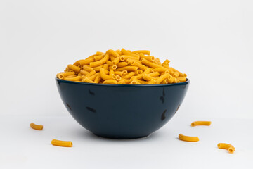 pasta horns in a deep blue bowl on a white background