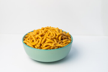 pasta horns in a green bowl on a white background
