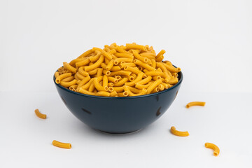 pasta horns in a deep blue bowl on a white background