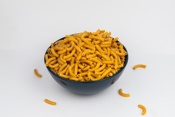pasta horns in a deep blue bowl on a white background