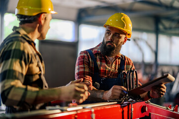 Main manager and his employee resolving production problem together.