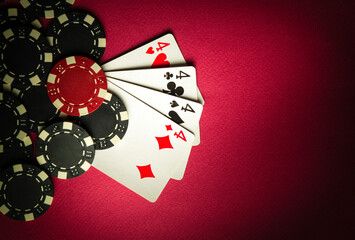 A popular poker game with a winning hand of four of four of a kind or quads. Cards and chips from winning on a red table in a poker club