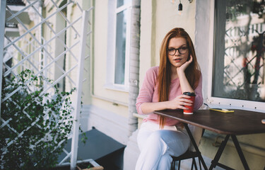 Cheerful woman with coffee cup sitting at table