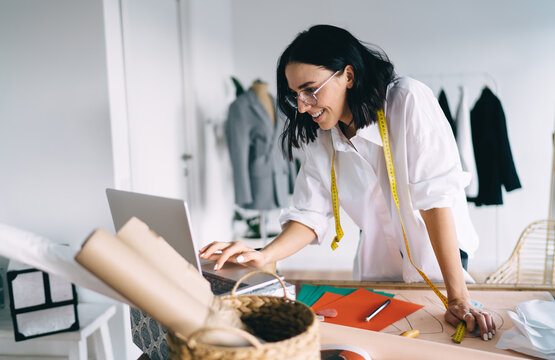 Cheerful female designer working on laptop