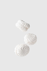 Three soaring white zephyr marshmallow on white background. flying food levitation