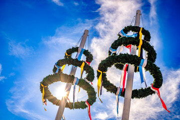 typical bavarian maypole in front of blue sky