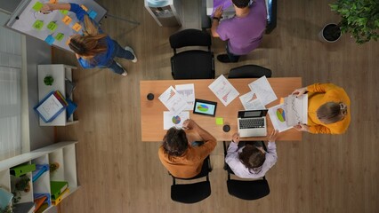 Top view of office boardroom with young men and women workers. Daily office life, people talking,...