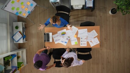 Top view of office boardroom with young men and women workers standing near the desk full of...