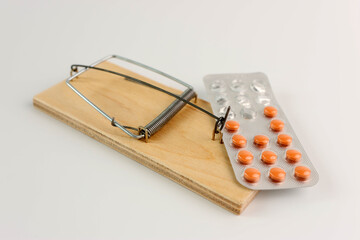 A person sets a trap in a mousetrap in the form of medicine. The concept of drug addiction.