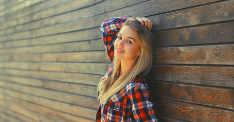 Portrait of beautiful caucasian blonde young woman in casual checkered shirt in the city