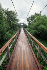 Wide angle, vertical photography. Bridge hanging on metal cables