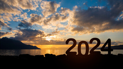 Silhouette happy new year 2024 message in starting new year 2020 concept with colorful sunrise...