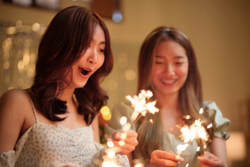 Women holding sparklers in winter christmas celebrate.