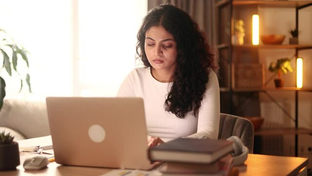 Confident freelancer having distance remote work typing browsing scrolling products in internet online store on laptop computer while sitting at desk workplace at home