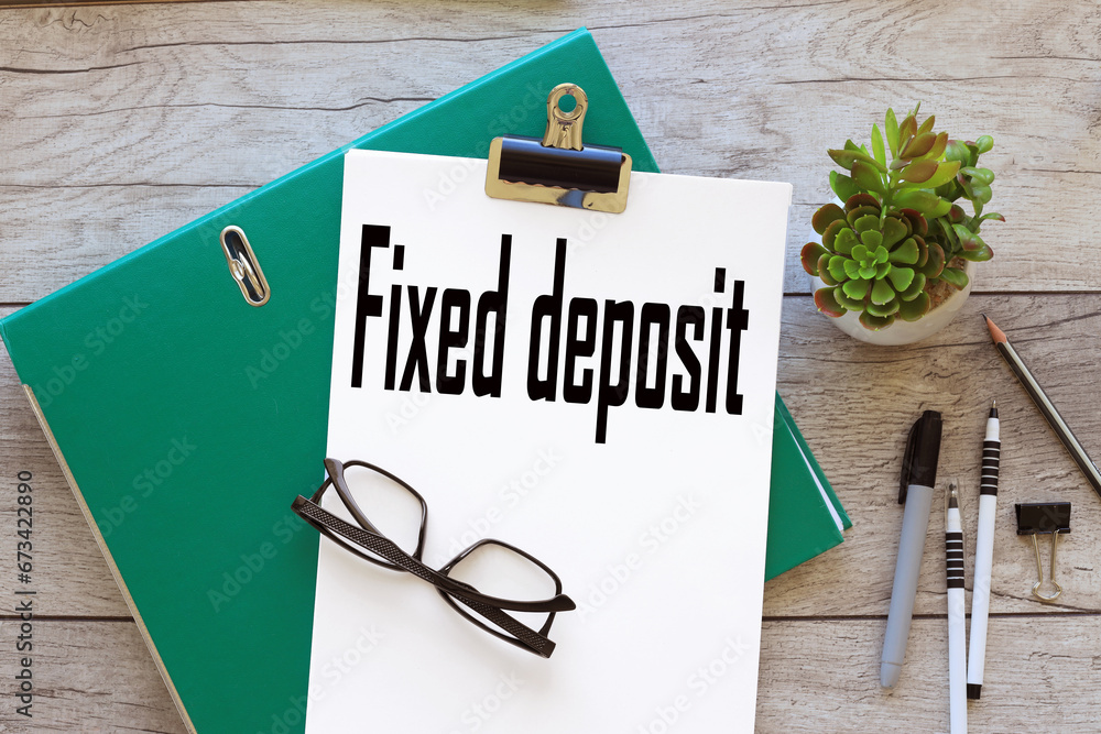 Aufkleber fixed deposit text on white a4 paper on a green folder