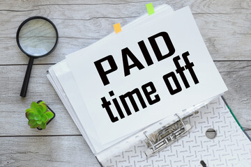Paid time off text on white paper on a folder with documents