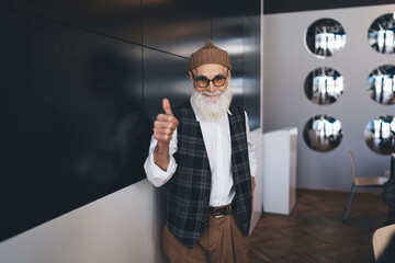 Content senior man showing thumb up in office