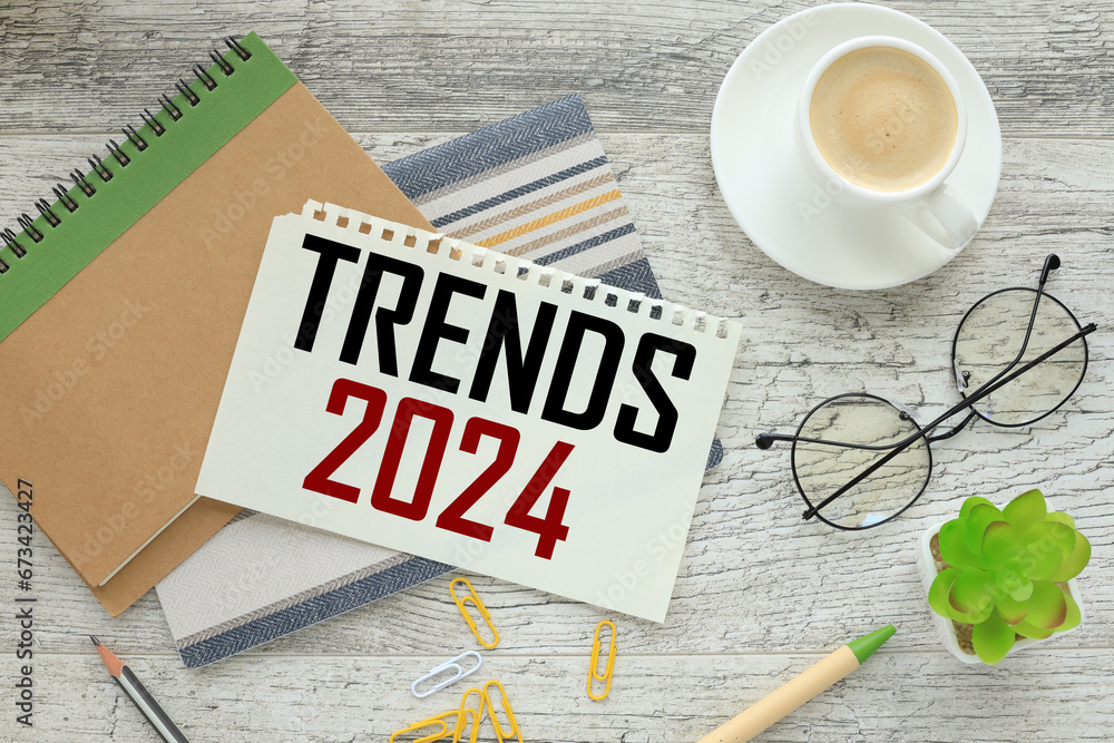 Poster top view of a cup of coffee and a notepad with text trends 2024