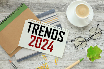 top view of a cup of coffee and a notepad with text TRENDS 2024