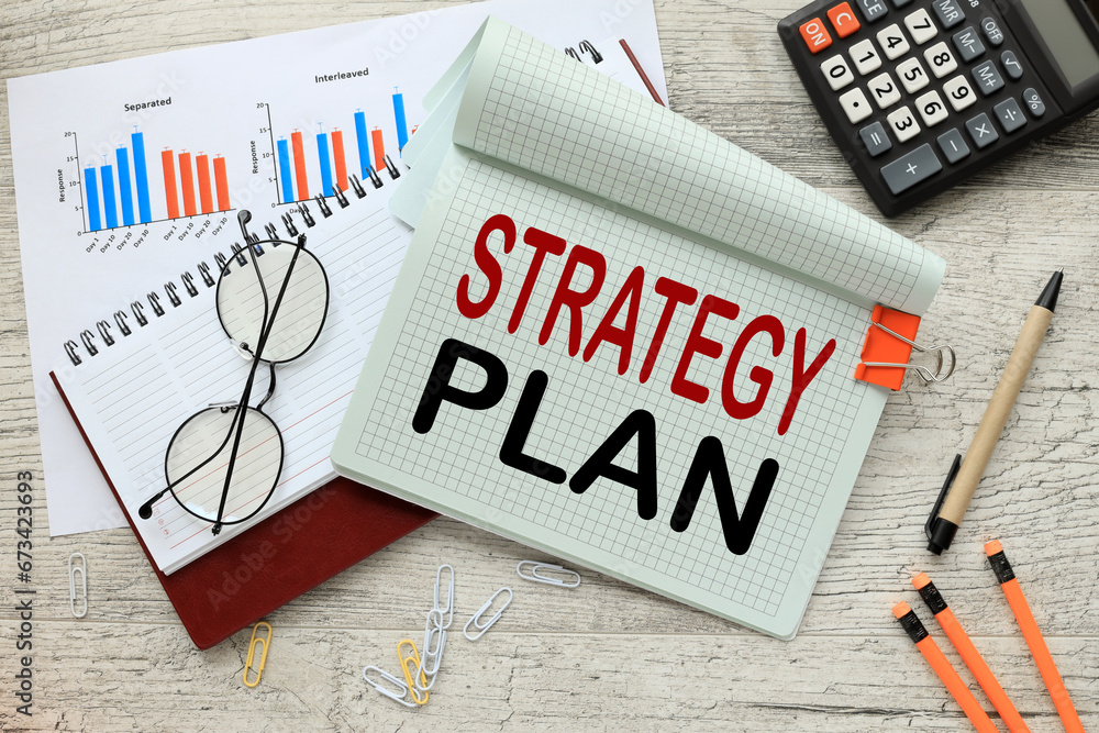 Poster top view of diary and notepad with text strategy plan