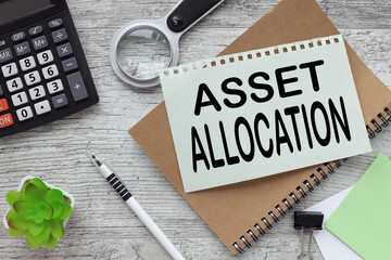 Asset Allocation text on the page. notepad near magnifying glass and calculator