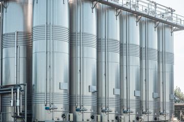 Close up of stainless vertical steel storage tanks for wine fermentation and maturation in modern...