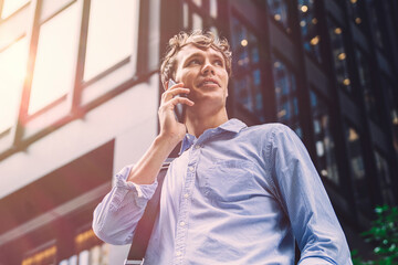 Office worker communicates by mobile phone call. Ordering taxi on city street