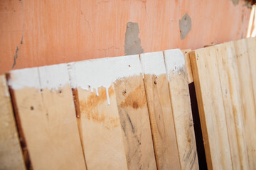 Painting works indoors and outdoors. Renovation of premises. White paint drips down the wood. Abstract background.